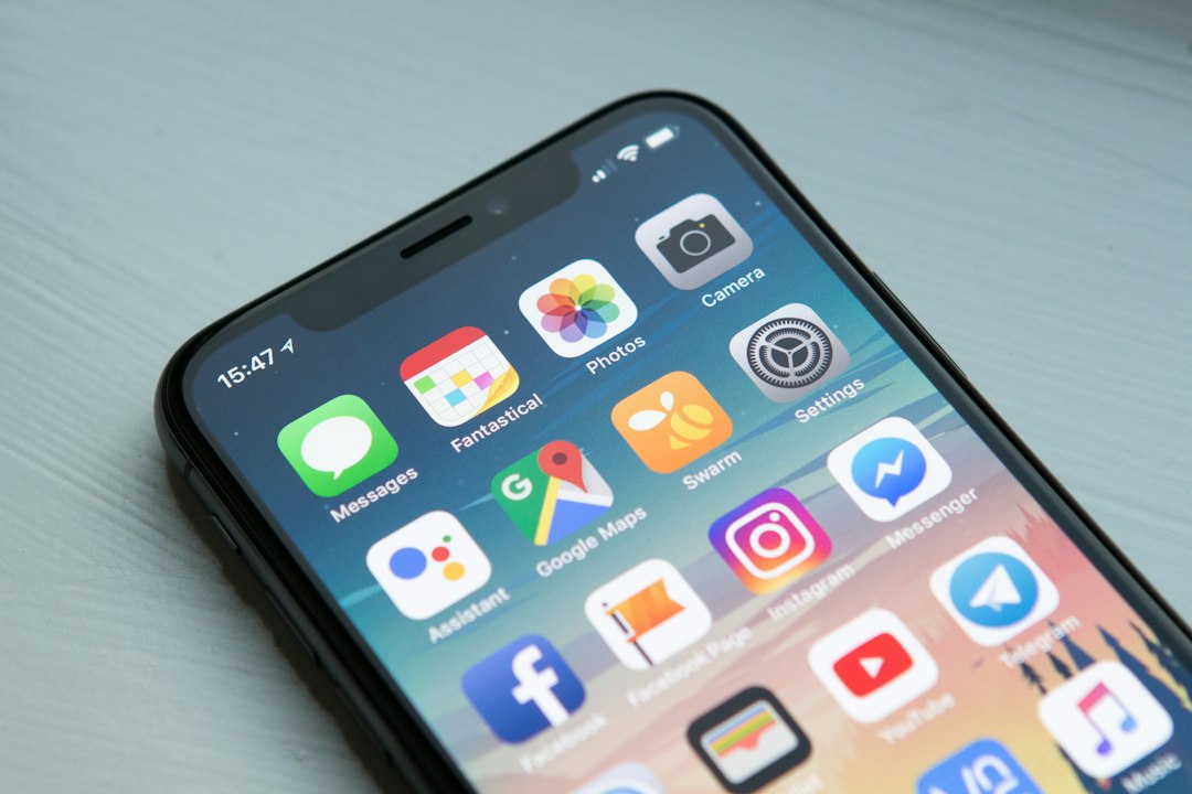Dueño de PyME revisando aplicaciones móviles a la medida en su smartphone y tablet